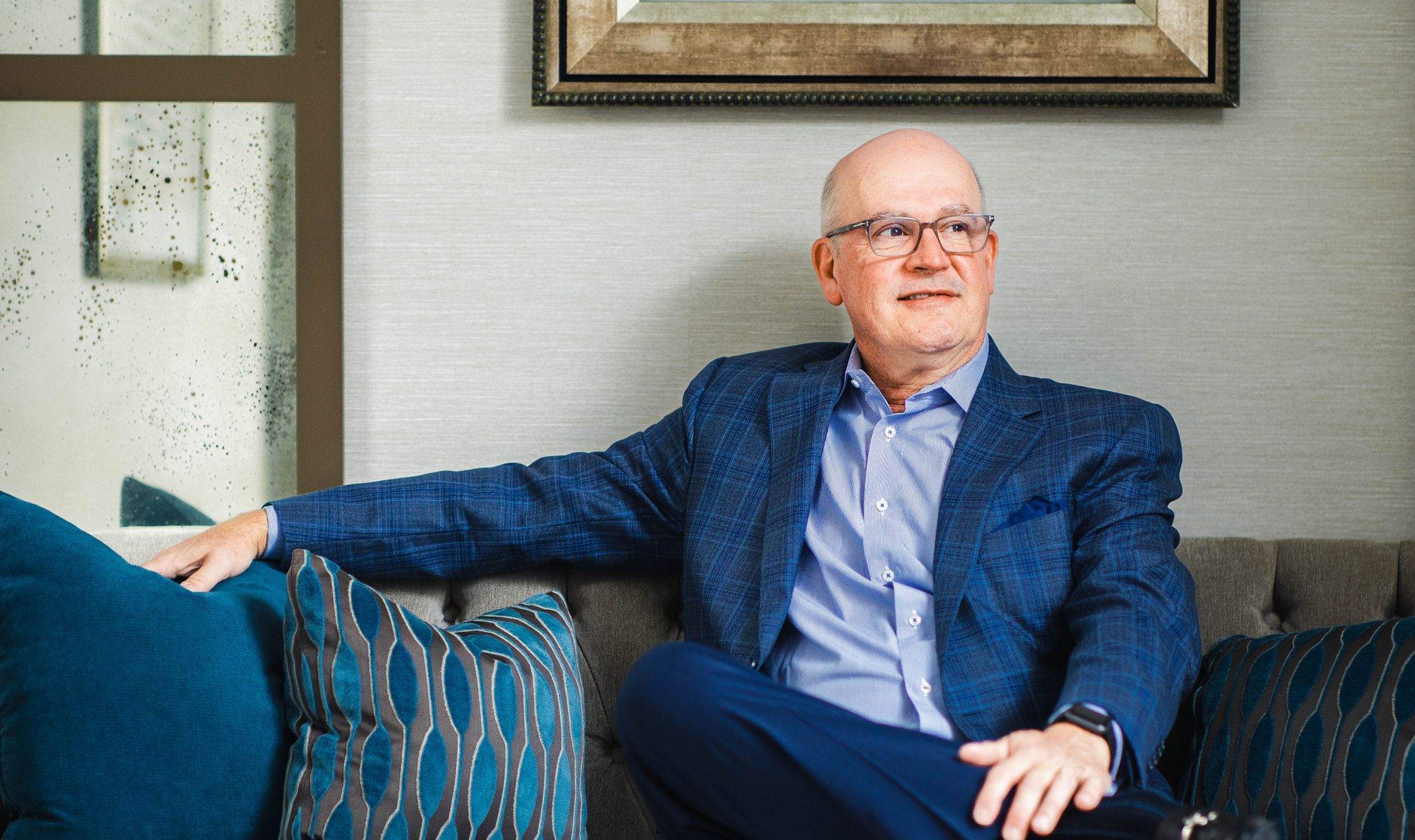 Man sitting on a sofa with decorative pillows.