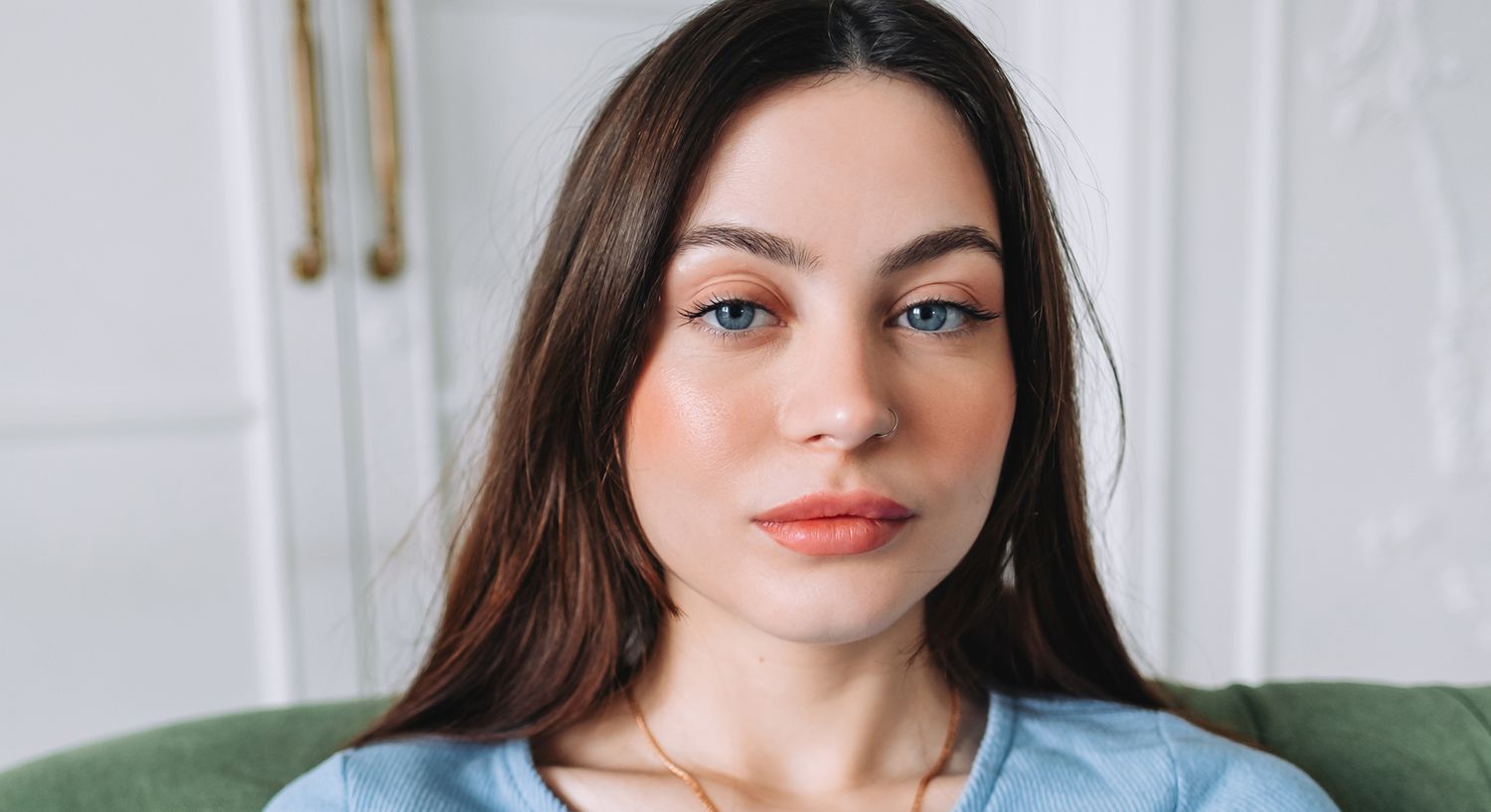 Young woman with dark hair and blue eyes.